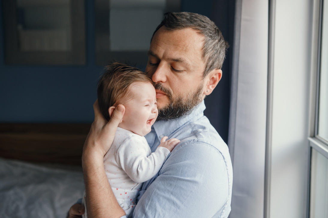 Middle Age Caucasian Father Trying to Calm down Newborn Baby